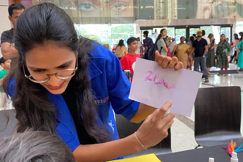 A MakerMasti host writing a name card at a make-and-take station