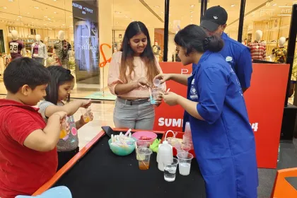 A child pouring a coloured solution into cups at a mall science counter