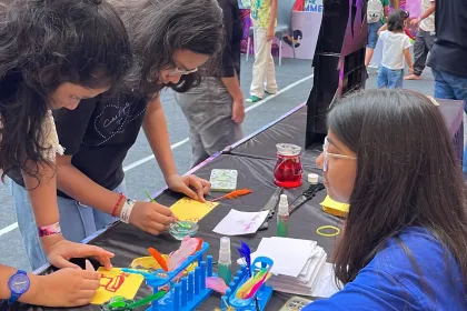 Adults working shoulder to shoulder over a craft table at a MakerMasti activation