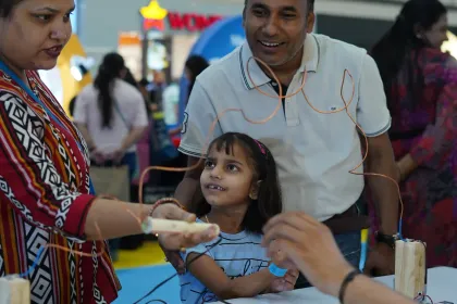 A father and daughter working on a hands-on build together while a MakerMasti host guides them