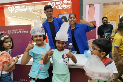 Children in shower caps giving a thumbs-up at The Great Indian Science Fest